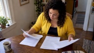 Homeowner comparing three written moving estimates